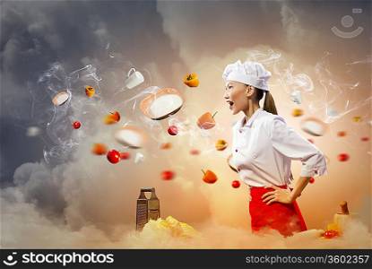 Asian female cook in anger with flyung vegetables against color background with shine effects