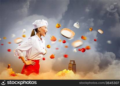 Asian female cook in anger with flyung vegetables against color background with shine effects