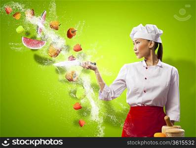 Asian female cook with knife cutting fruits and vegetables in air