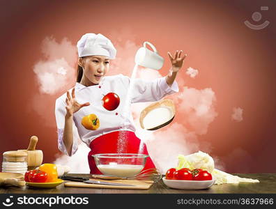 Asian female cooking with magic against color background