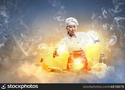 Asian female cooking with magic. Asian female cooking with magic against color background