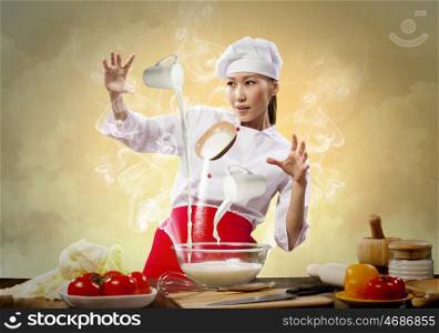 Asian female cooking with magic. Asian female cooking with magic against color background