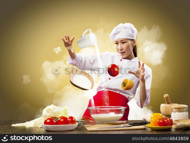 Asian female cooking with magic. Asian female cooking with magic against color background