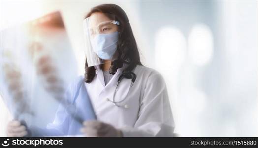 asian female doctor looking at the x-ray picture of lungs in hospital