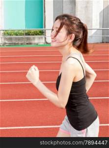 Asian female jogger on track at a stadium jogging in race