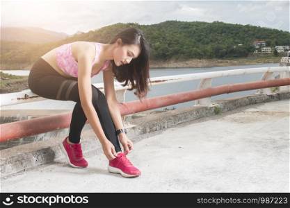 Asian female sport fitness runner getting ready for jogging outdoors