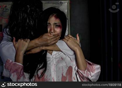 Asian Female victim was made to keep silence while standing alone in dark night. Halloween and Horror Concept.