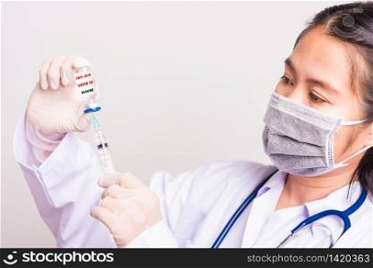 "Asian female woman doctor or nurse in PPE uniform and gloves wearing face mask protective in lab hold needle syringe drug and medicine vial vaccine bottle on bottle has "COVID-19 VACCINE" text label"