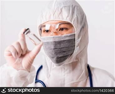 Asian female woman doctor or nurse in PPE uniform and gloves with wearing face mask protective in the laboratory holding medicine vial vaccine bottle isolated white background, Health medical concepts