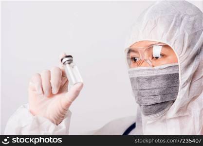 Asian female woman doctor or nurse in PPE uniform and gloves with wearing face mask protective in the laboratory holding medicine vial vaccine bottle isolated white background, Health medical concepts