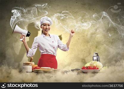 Asian female young cook smiling holding megaphone