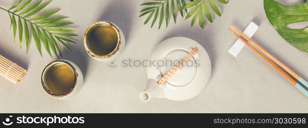 Asian food background - tea and chopsticks on a grey concrete background. Top view, flat lay. Asian food background . Asian food background