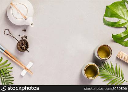 Asian food background - tea and chopsticks on a grey concrete background. Top view, flat lay. Asian food background . Asian food background