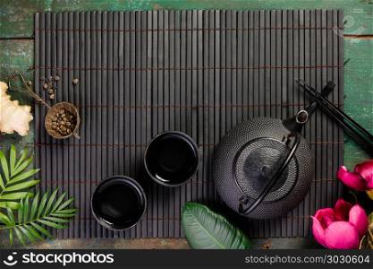 Asian food background - tea and chopsticks on dark rustic background. Top view, flat lay. Asian tea concept. Asian tea concept