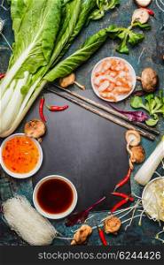Asian food background with cooking ingredients, chopsticks and sauces, frame