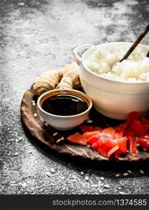 Asian food. Boiled rice with soy sauce and pickled ginger. On an old rustic background. Japanese cuisine table.. Asian food. Boiled rice with soy sauce and pickled ginger. On an old rustic background.