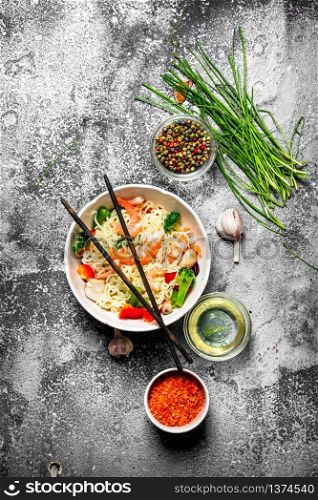 Asian food. Chinese noodles with vegetables and shrimp. On an old rustic background .. Asian food. Chinese noodles with vegetables and shrimp.