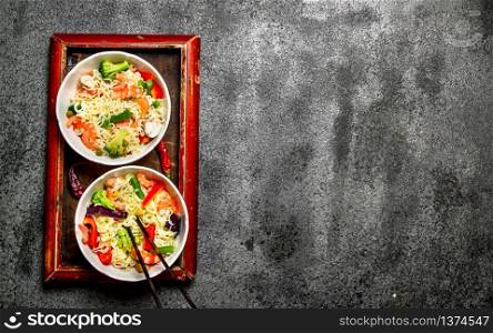 Asian food. Chinese noodles with vegetables. On rustic background .. Asian food. Chinese noodles with vegetables.