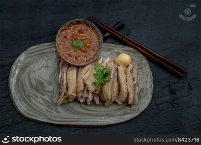 Asian food style marinated steamed chicken  Betong Chickken  and sauce on ceramic plate. Serving chilled as an appetizer. Top view.