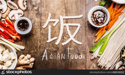 Asian food with various vegetables cooking ingredients on wooden background with Chinese hieroglyph of food, top view, banner