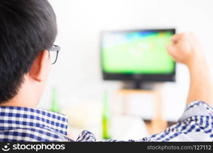 Asian football supporters group of friend watching soccer sport match on tv and cheering, celebrating with beer and popcorn at home with fun or disappoint emoticon.