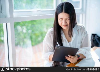 asian freelance people business female wearing smartwatch talking making using casual working with tablet for browsing internet, chatting and blogging and smartphone,notebook in coffee shop.