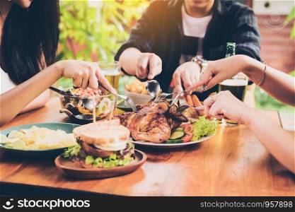 Asian friends enjoying eating turkey at restaurant.