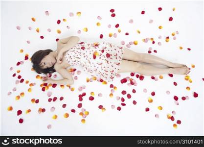Asian girl in white dress with petals