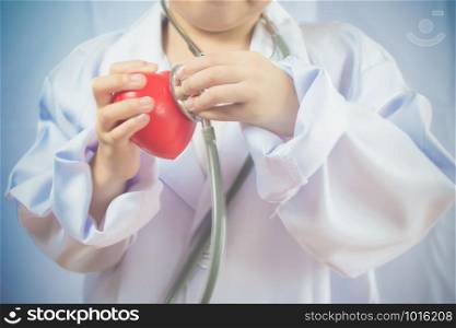Asian girl playing as a doctor care healthy heart