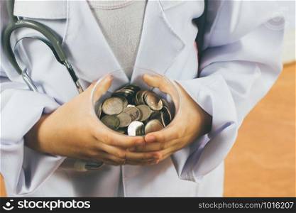 Asian girl playing as a doctor care money in cup