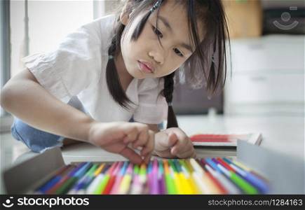 asian girl playing color pencil in home living room
