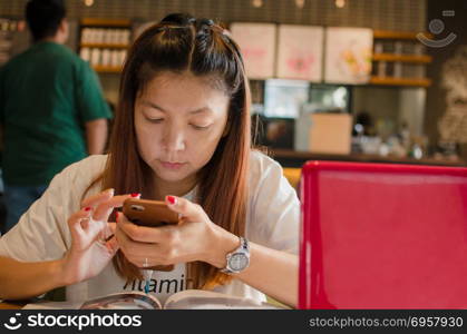 Asian girl sitting and working in a coffee shop. girl in the cafe