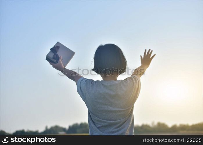Asian Girl standing hold gift box to sky