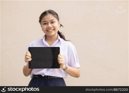 Asian girl teen student hand hold tablet blank screen space for advertising text in school uniform happy smile isolated.