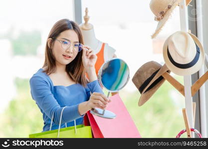 Asian girl teen try on glasses in fashion accessories shop, Testing eye glass.