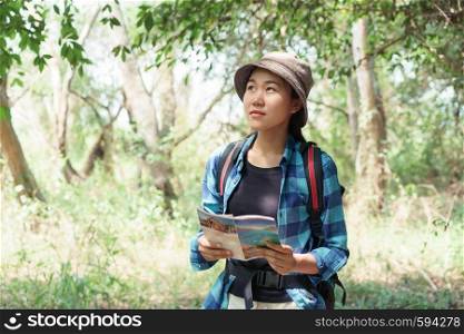 Asian girl tourists are traveling in the nature of the forest, Teenage women traveling to relax are relaxing in the midst of the nature of green trees.