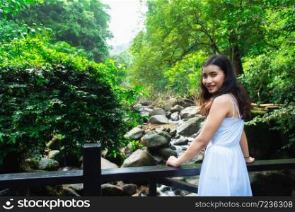 Asian girl tourists visit the beauty of nature in Phlio Waterfall National Park sign at Chanthaburi, Thailand.