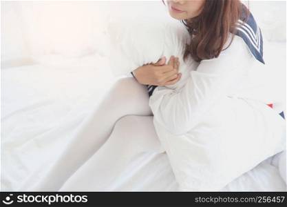 Asian girl wake up with school girl uniform in bedroom