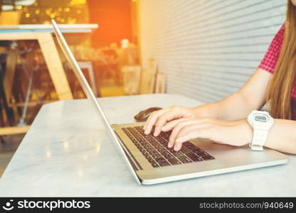 Asian girl working at a coffee shop sitting with mobile phone and laptop. Manager doing job at loft office