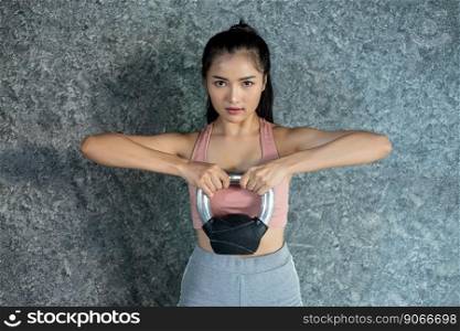 Asian girls are exercising with the Kettlebell in the gym.