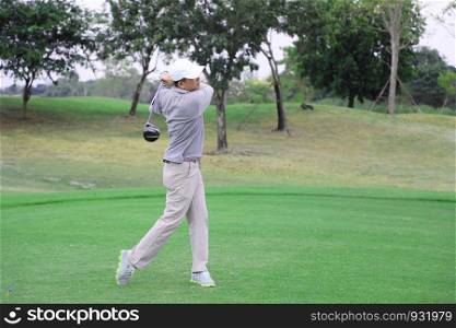 Asian golfer teeing off golf ball from tee box with his golf club