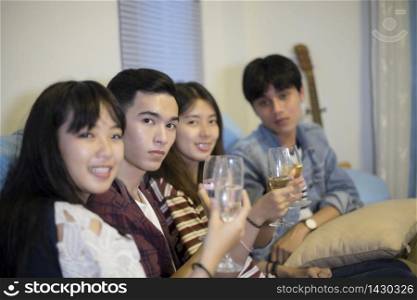 Asian group of friends having party with alcoholic beer drinks and Group people with champagne dancing at party.soft focus