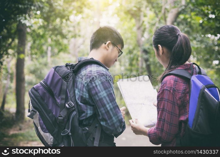 Asian Group of young people Hiking with friends backpacks walking together and looking map and taking photo camera by the road and looking happy ,Relax time on holiday concept travel