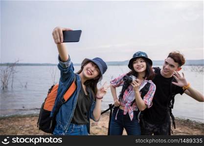 Asian Group of young people with friends and backpacks walking together and happy friends are taking photo and selfie ,Relax time on holiday concept travel