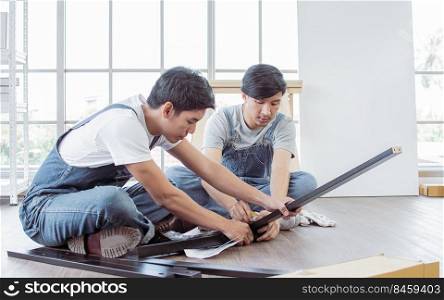 Asian handsome men are making an assembly of a furniture at home. Interior design and DIY Concept.