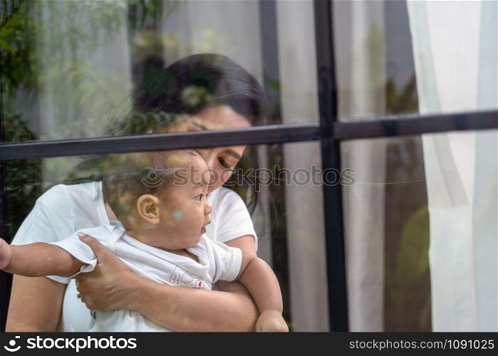 Asian Happiness family scene of mother Carry boy baby beside the windows in the house,Family Lifestyle Concept