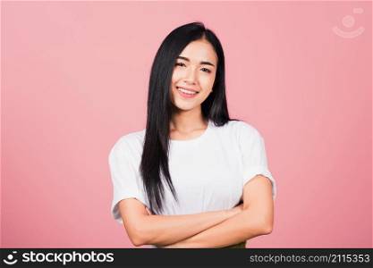 Asian happy portrait beautiful cute young woman standing her smile confidence with crossed arms isolated, studio shot on pink background and copy space, Thai female looking to camera