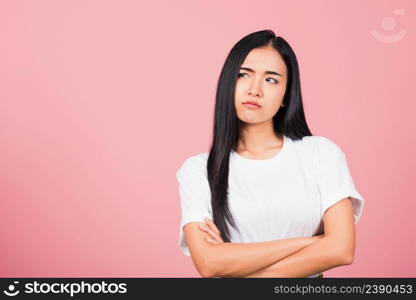 Asian happy portrait beautiful cute young woman standing with crossed arms angry and mad raising fist frustrated and furious while shouting with anger isolated, studio shot on pink background