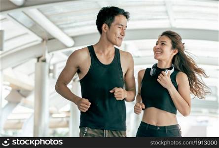 Asian Healthy and Sportive couple smiling to each other, running and jogging outdoor. Sport and Lifestyle Concept.