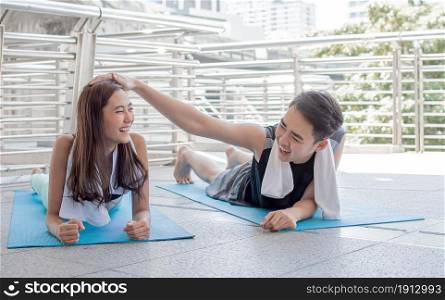 Asian healthy couple doing exercise and plank outside. Sport and Lifestyle Concept.
